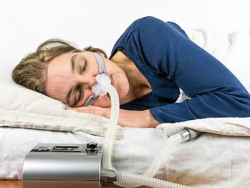 Woman sleeping while wearing a CPAP mask for sleep apnea therapy